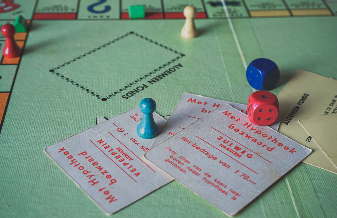 Close-up of vintage Monopoly game pieces and cards on a game board.